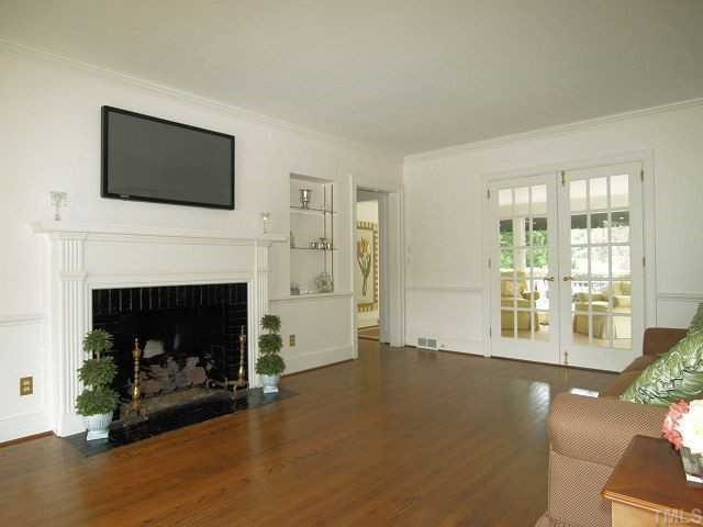 Formal living room boasts gas log fireplace, gorgeous mantle, hardwood floors, beautiful windows, and french doors that open to bright sunroom. Living Room
