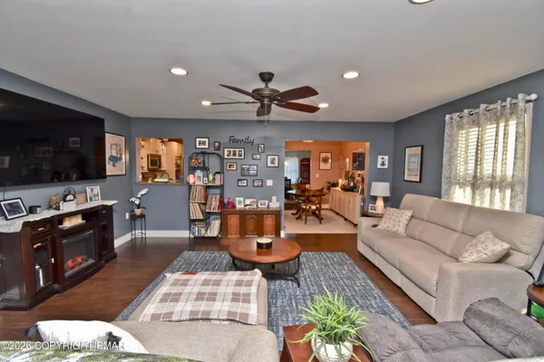a living room with furniture kitchen view and a flat screen tv