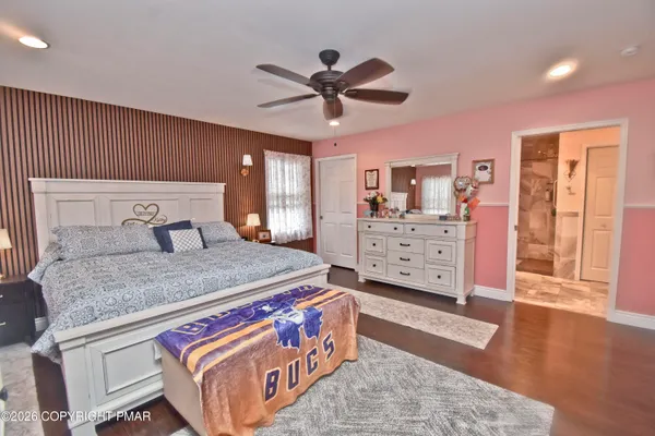 a bedroom with a bed and wooden floor
