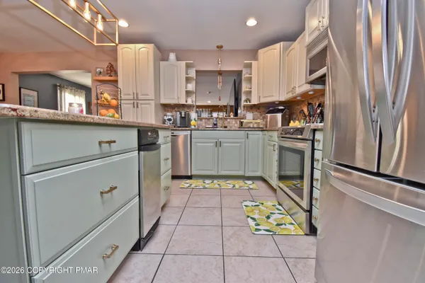 a kitchen with stainless steel appliances granite countertop a refrigerator sink and stove