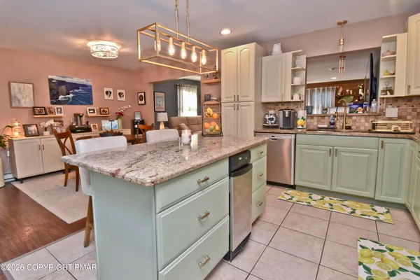 a kitchen with granite countertop kitchen island stainless steel appliances a sink and cabinets