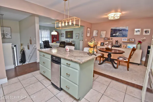 a view of kitchen with granite countertop cabinets table and chairs