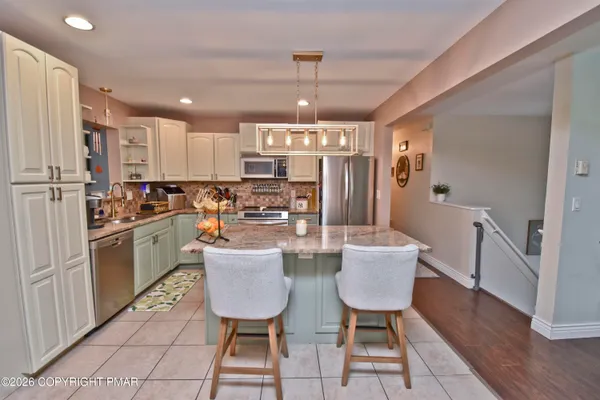a kitchen with refrigerator and chairs
