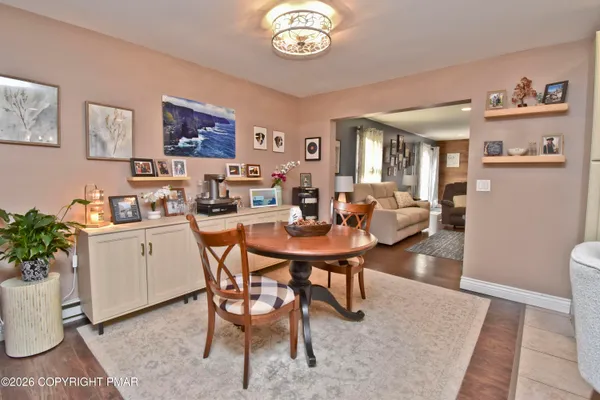 a dining room with furniture a rug and a potted plant
