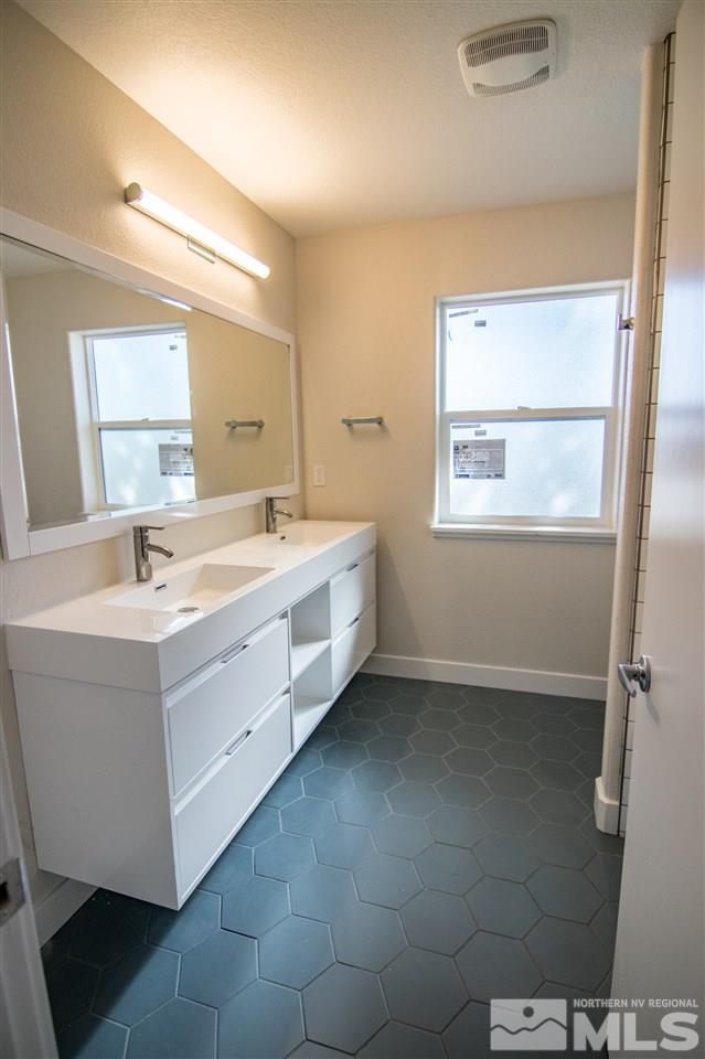 40 Park Street Reno, NV 89502 - Photo 3 of 16 a bathroom with a double vanity sink a mirror and a bathtub