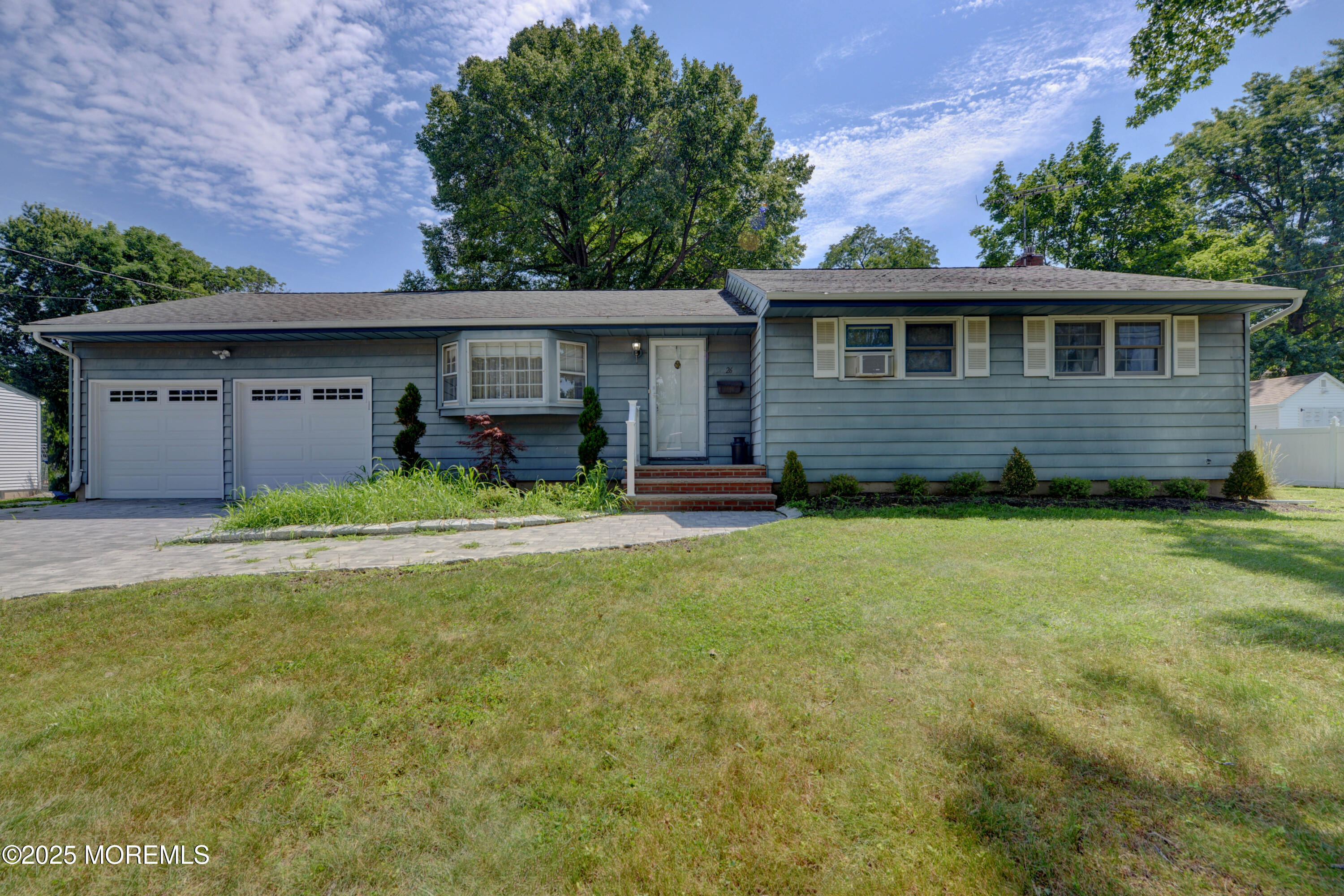 26 Old Manor Road Holmdel, NJ 07733 - Photo 35 of 37 a front view of a house with a yard and garage