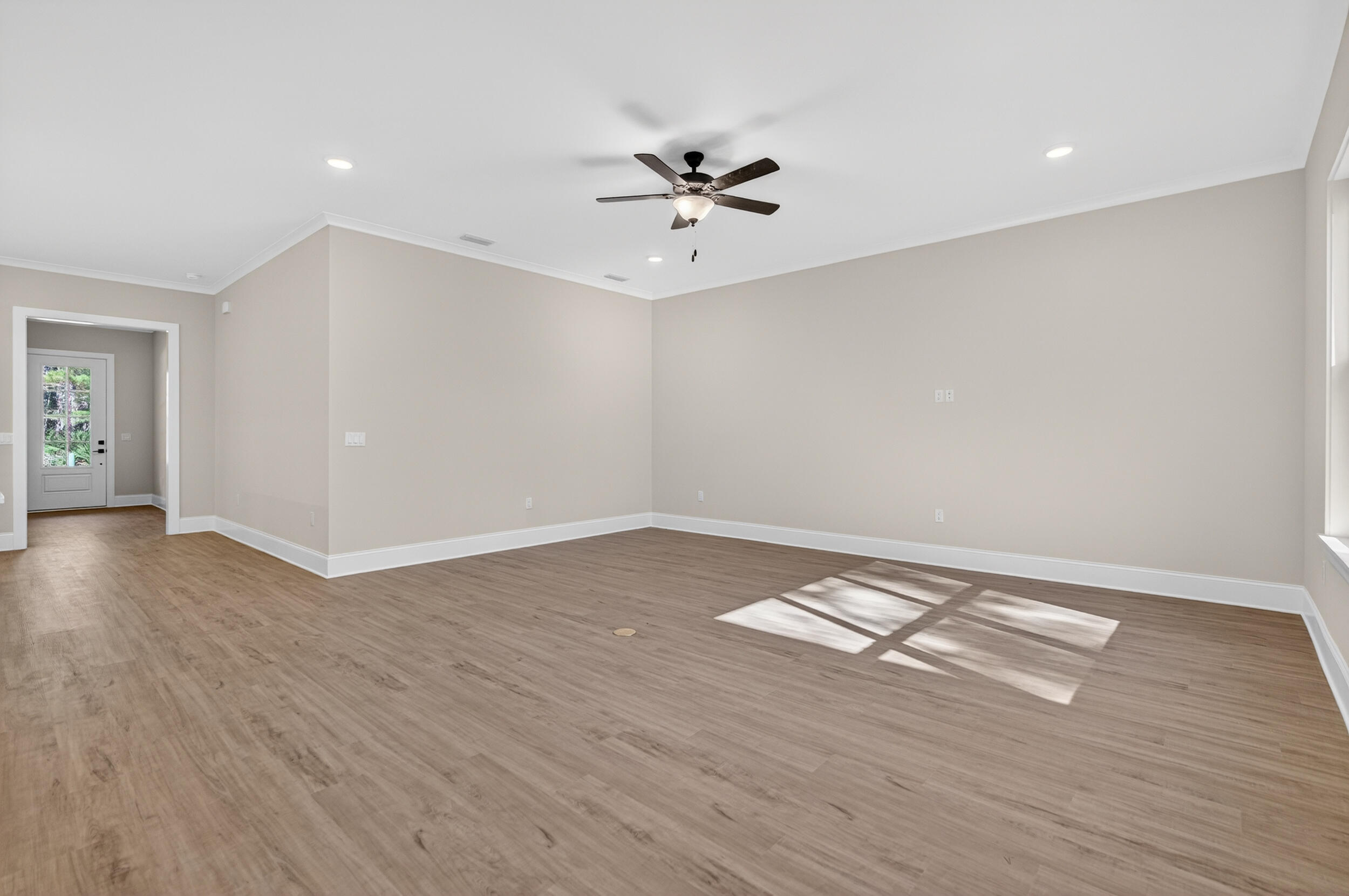 397 North J Hunter's Way, Unit LOT 36 Freeport, FL 32439 - Photo 12 of 54 an empty room with wooden floor ceiling fan and windows