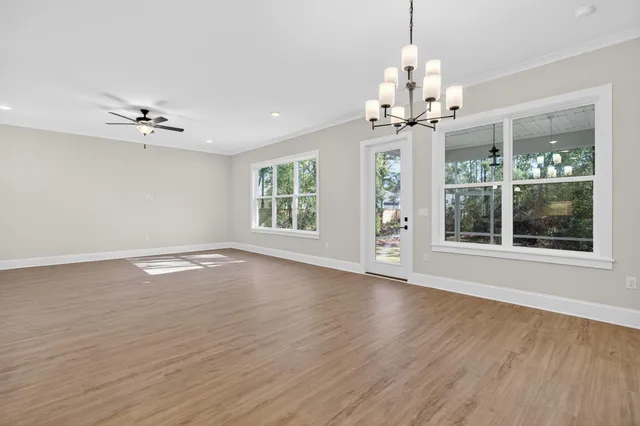 a kitchen with stainless steel appliances granite countertop a sink a stove a refrigerator and white cabinets with wooden floor