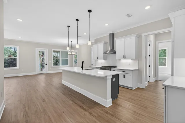 a kitchen with a sink a stove a refrigerator and white cabinets