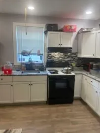 a kitchen with granite countertop a sink cabinets and stainless steel appliances