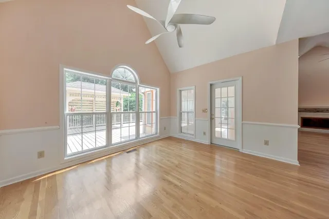 an empty room with wooden floor and fireplace