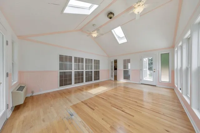 an empty room with a window and a ceiling fan