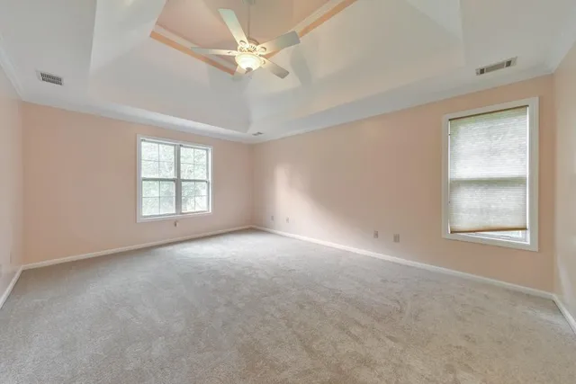 an empty room with a window and a ceiling fan