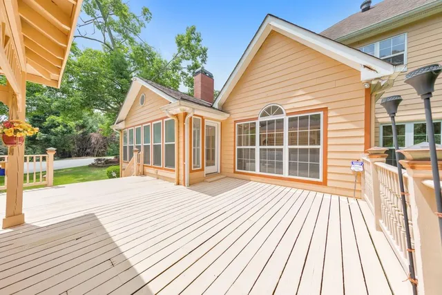 an empty room with a chandelier fan and windows