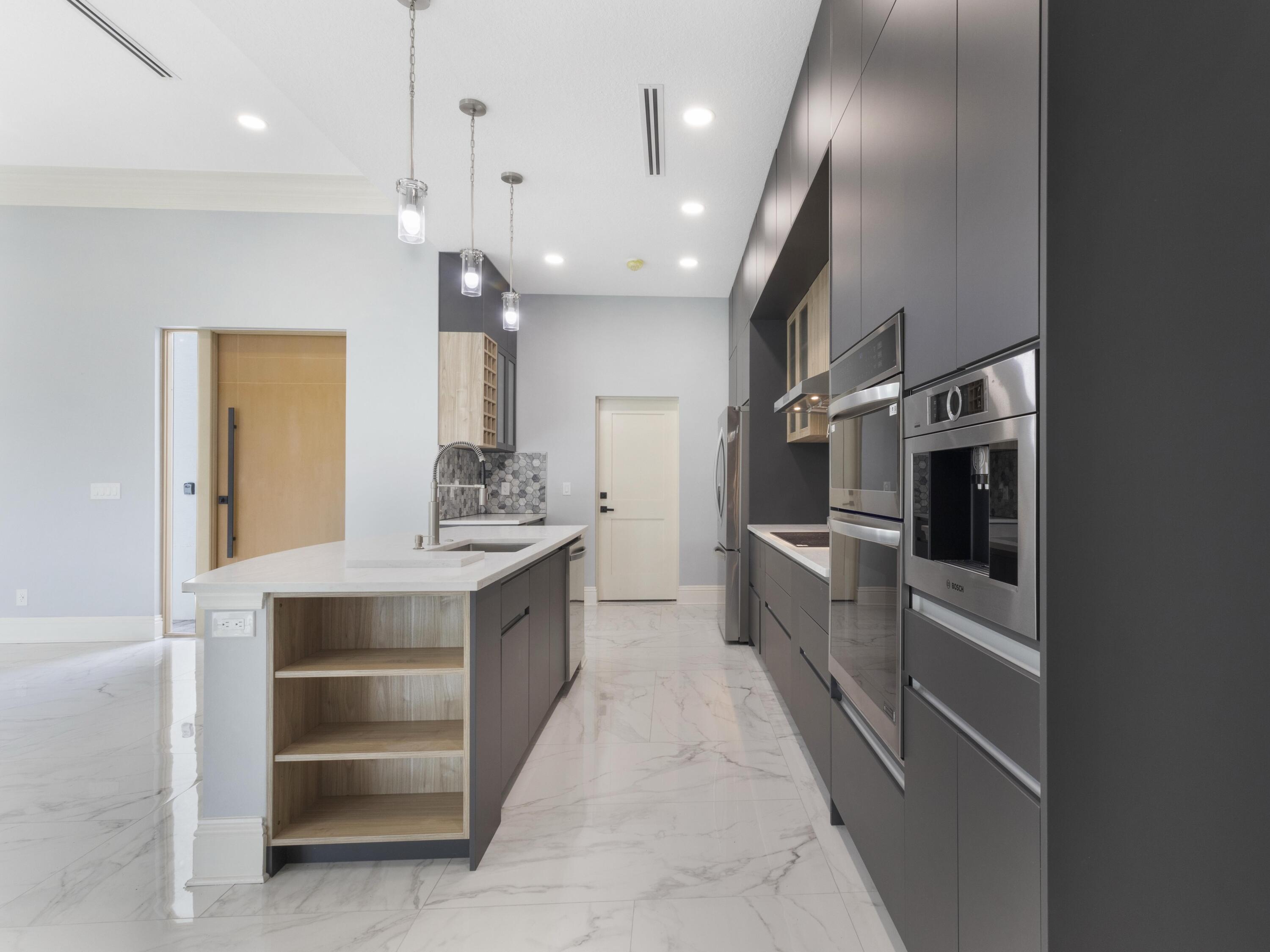17436 71st Lane North Loxahatchee, FL 33470 - Photo 12 of 50 a large white kitchen with a sink stainless steel appliances and cabinets
