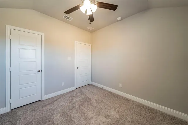 an empty room with a chandelier fan