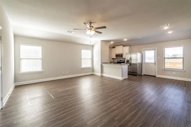 a view of a kitchen with a stove wooden floor and a window