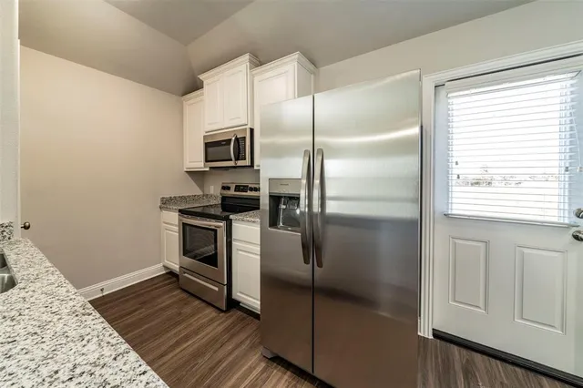 a kitchen with cabinets and stainless steel appliances