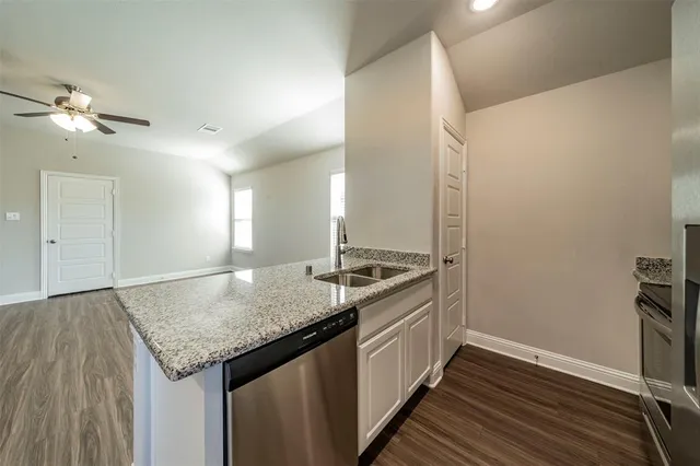 a kitchen with granite countertop cabinets appliances and a counter space