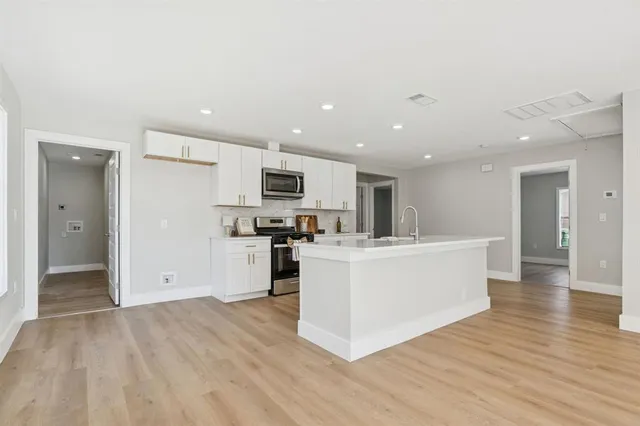 a kitchen with white cabinets and white appliances