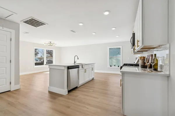 a kitchen with stainless steel appliances granite countertop a stove a sink and a microwave