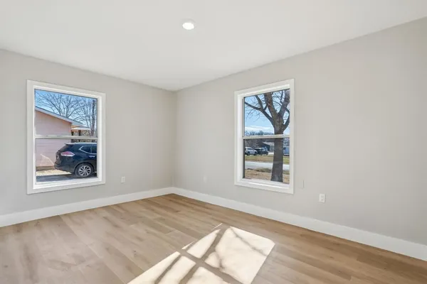 a large white kitchen with wooden floors and white stainless steel appliances