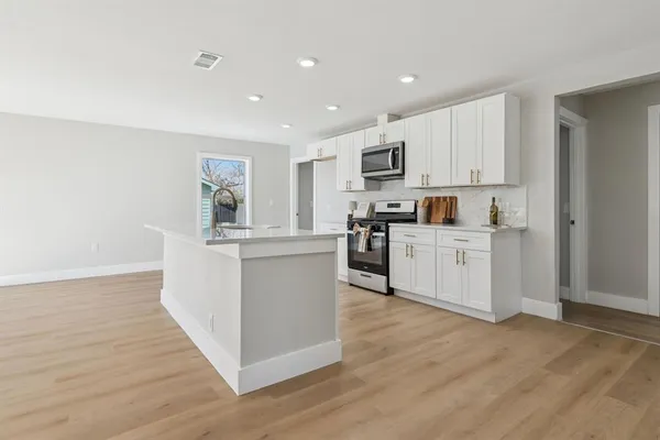 a kitchen with white cabinets and white appliances