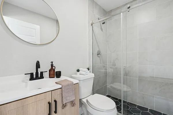 a bathroom with a sink a toilet and shower