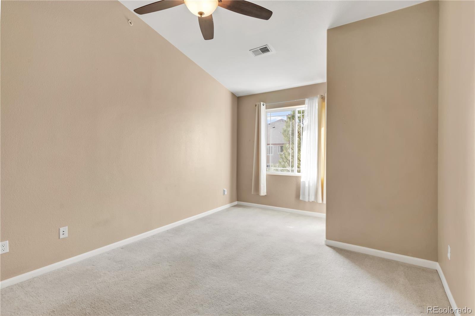 8456 South Hoyt Way, Unit 301 Littleton, CO 80128 - Photo 16 of 31 an empty room with a chandelier fan and windows