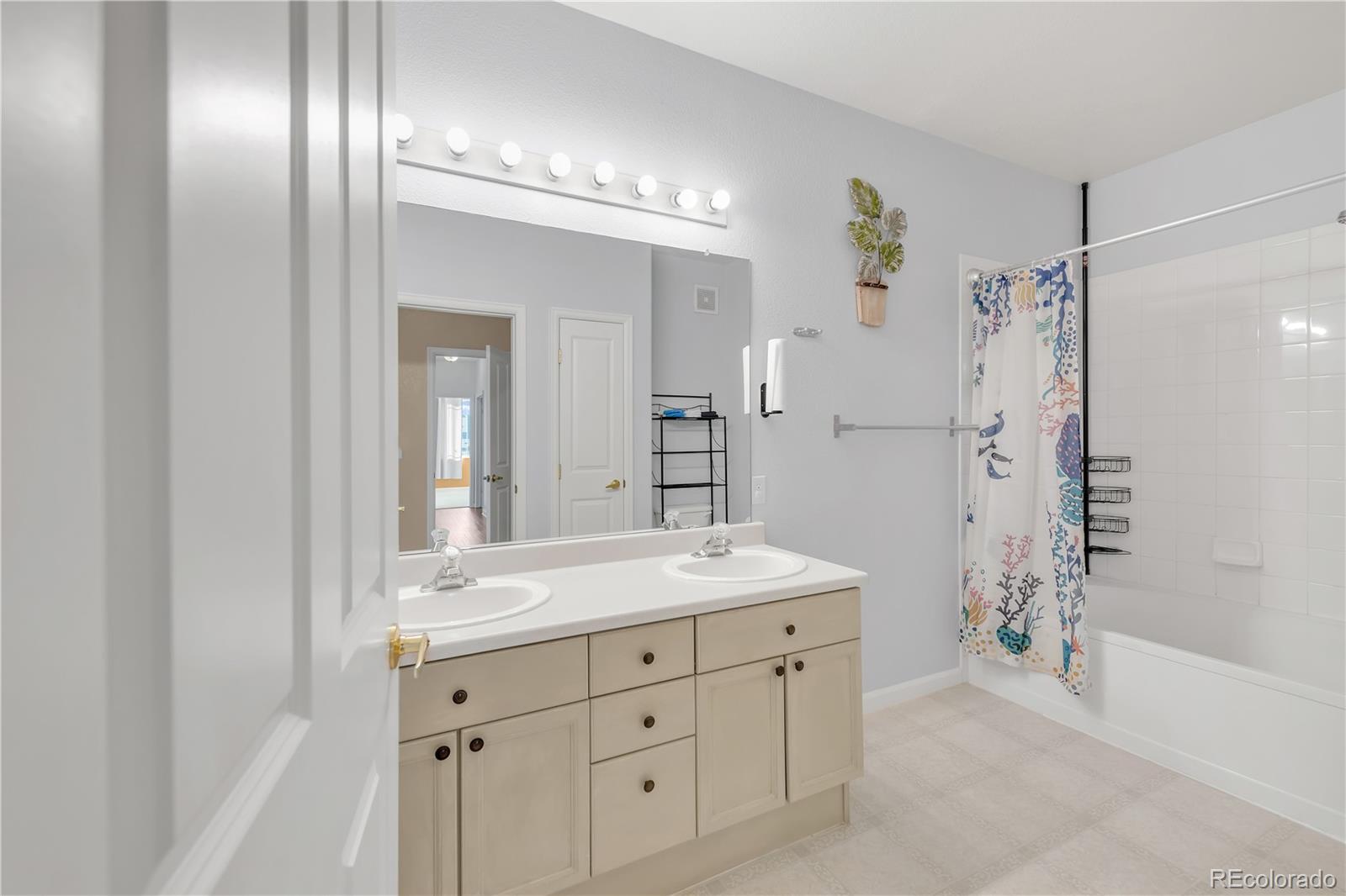 8456 South Hoyt Way, Unit 301 Littleton, CO 80128 - Photo 17 of 31 a spacious bathroom with a shower a sink and a mirror
