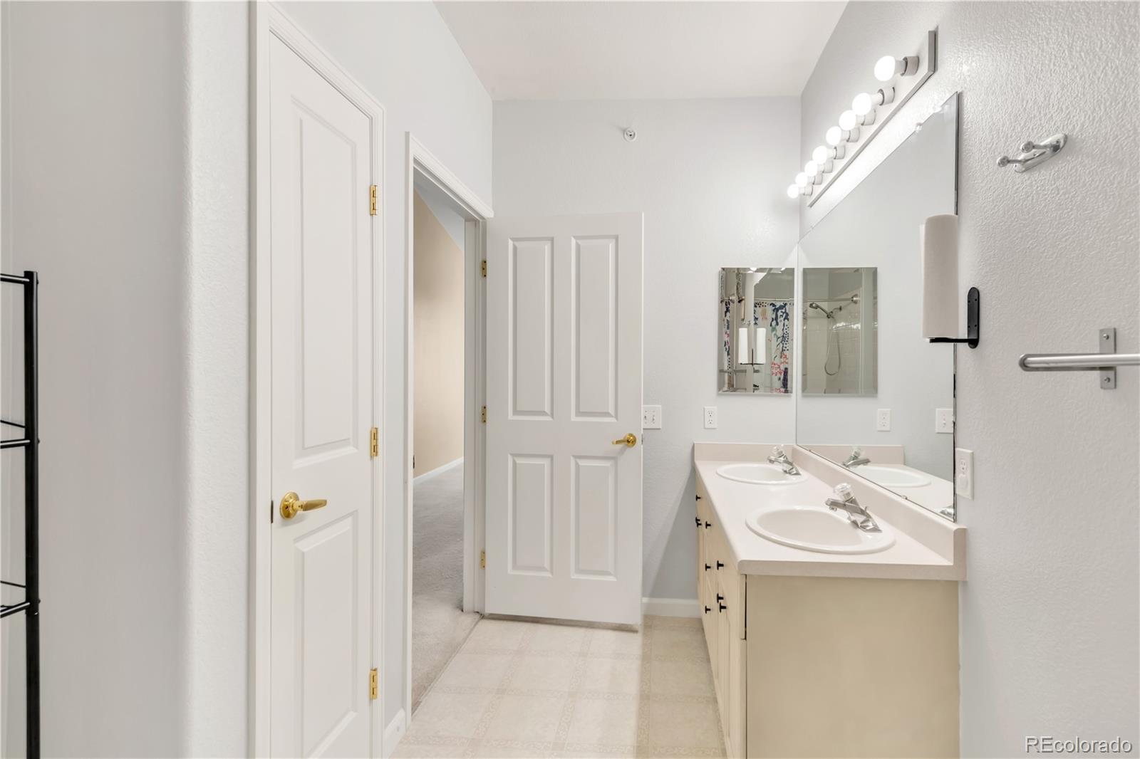 8456 South Hoyt Way, Unit 301 Littleton, CO 80128 - Photo 19 of 31 a bathroom with a sink a mirror and a shower