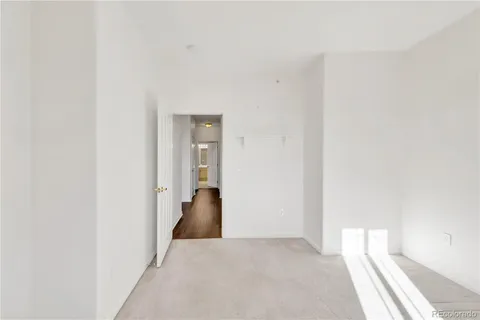 a view of hallway with closet and wooden floor