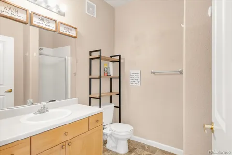 a bathroom with a granite countertop sink toilet and shower