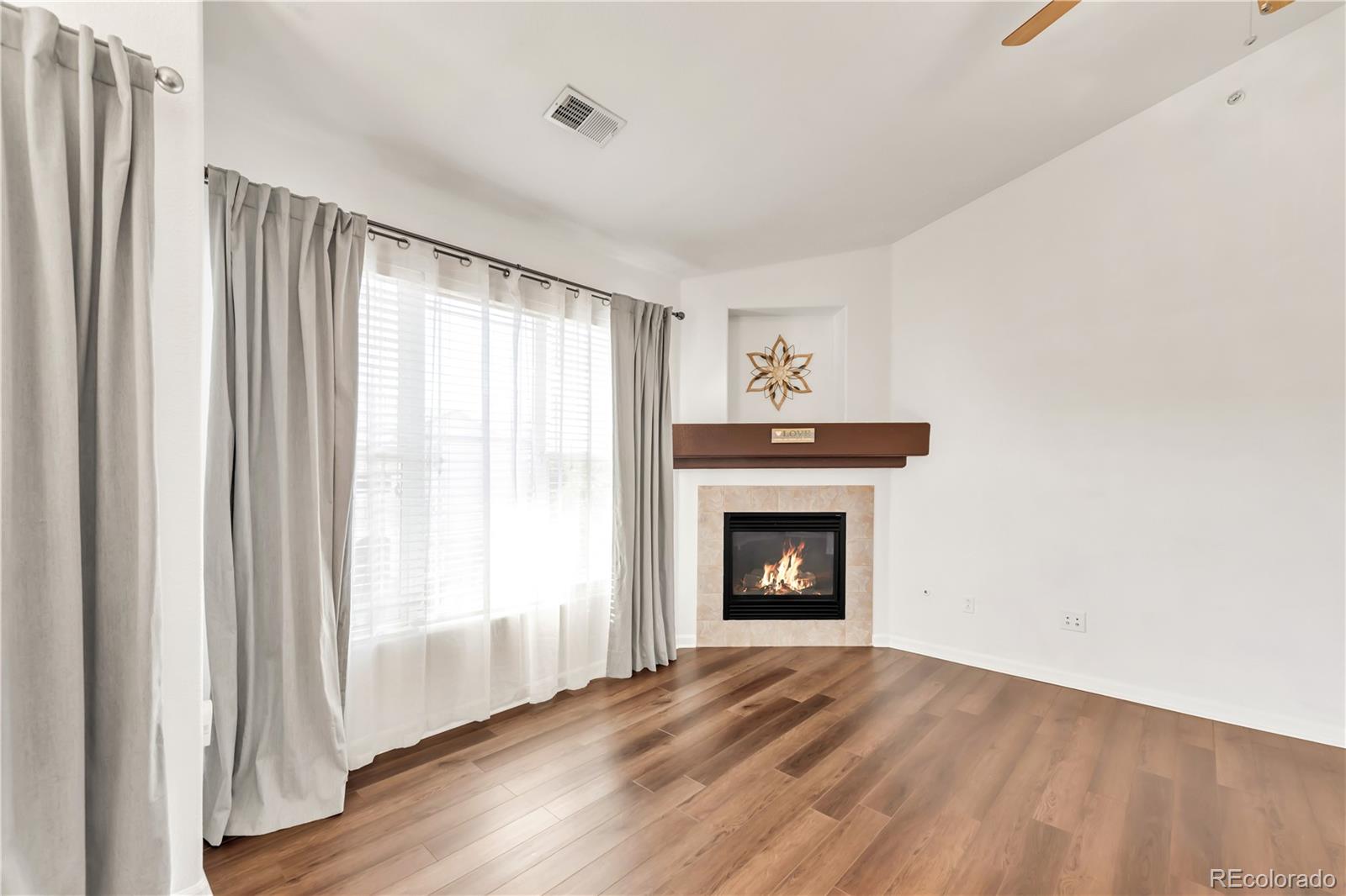 8456 South Hoyt Way, Unit 301 Littleton, CO 80128 - Photo 7 of 31 a view of empty room with wooden floor and fireplace
