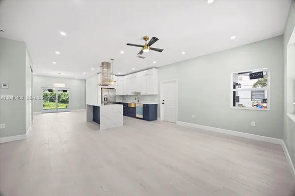 an open kitchen with a refrigerator a ceiling fan and a kitchen view