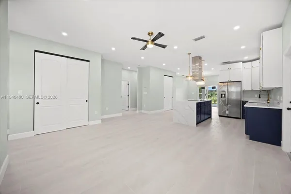 a view of kitchen with kitchen island stainless steel appliances refrigerator stove microwave and cabinets