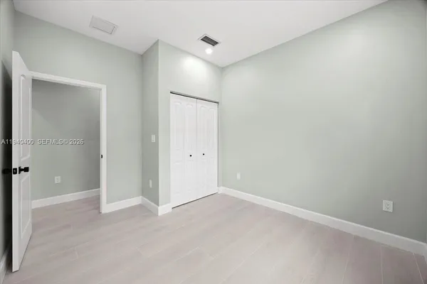 an empty room with closet and wooden door