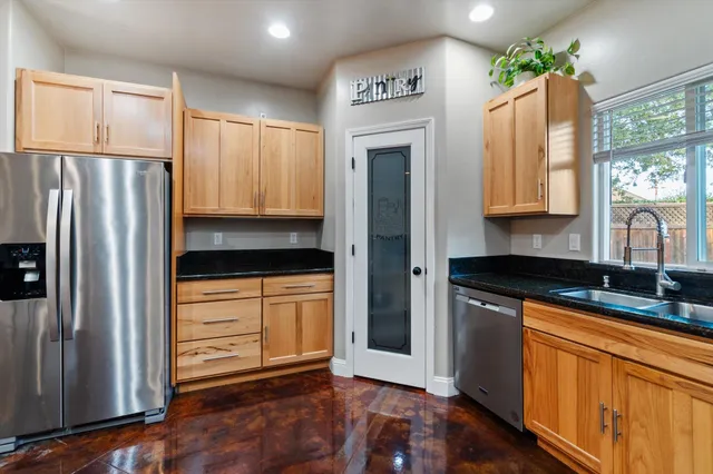 a kitchen with granite countertop a refrigerator and a sink
