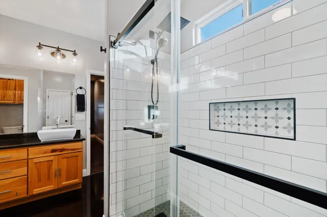 a bathroom with a shower sink and mirror