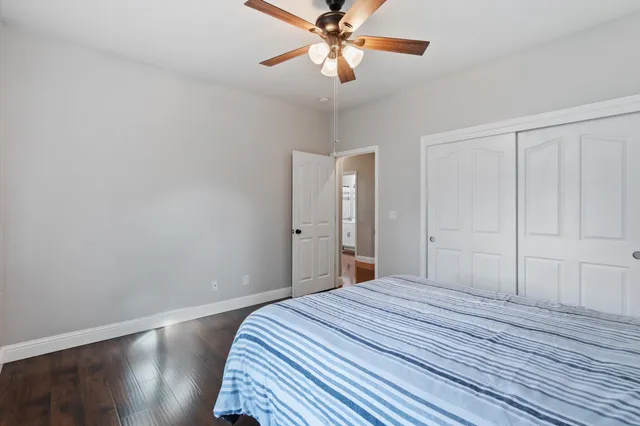a bedroom with a bed and a chandelier fan