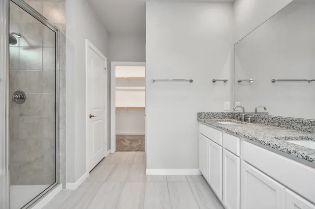 a bathroom with a granite countertop sink and shower