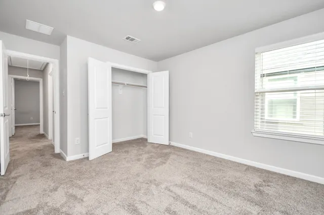 an empty room with windows and closet