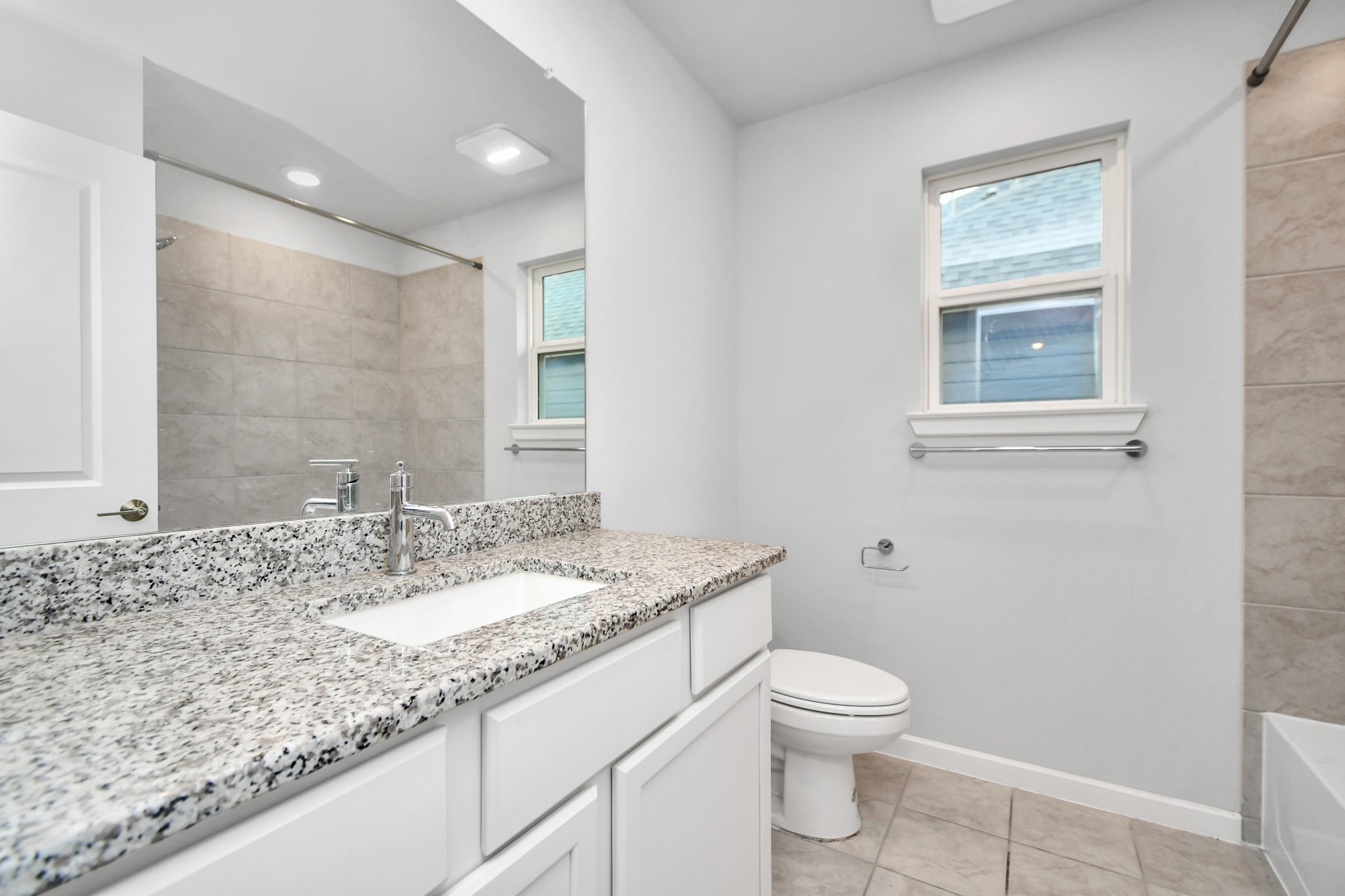1218 Raburn Run Lane Tomball, TX 77375 - Photo 29 of 37 a bathroom with a granite countertop sink a toilet and a mirror