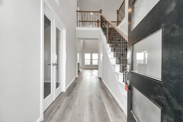 a view of a hallway with wooden floor and staircase