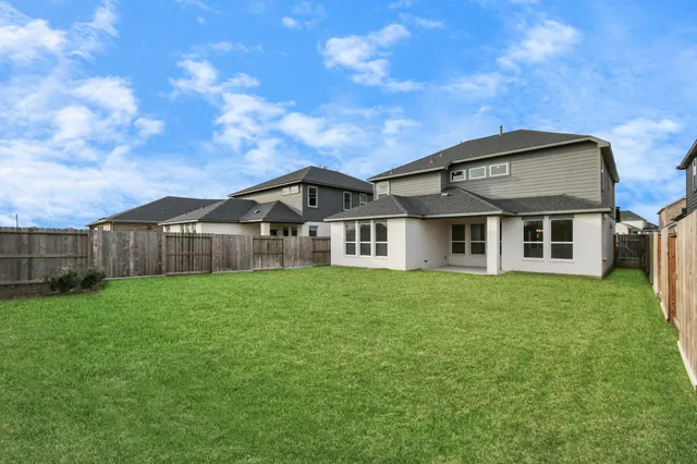 a view of a big house with a big yard and large trees