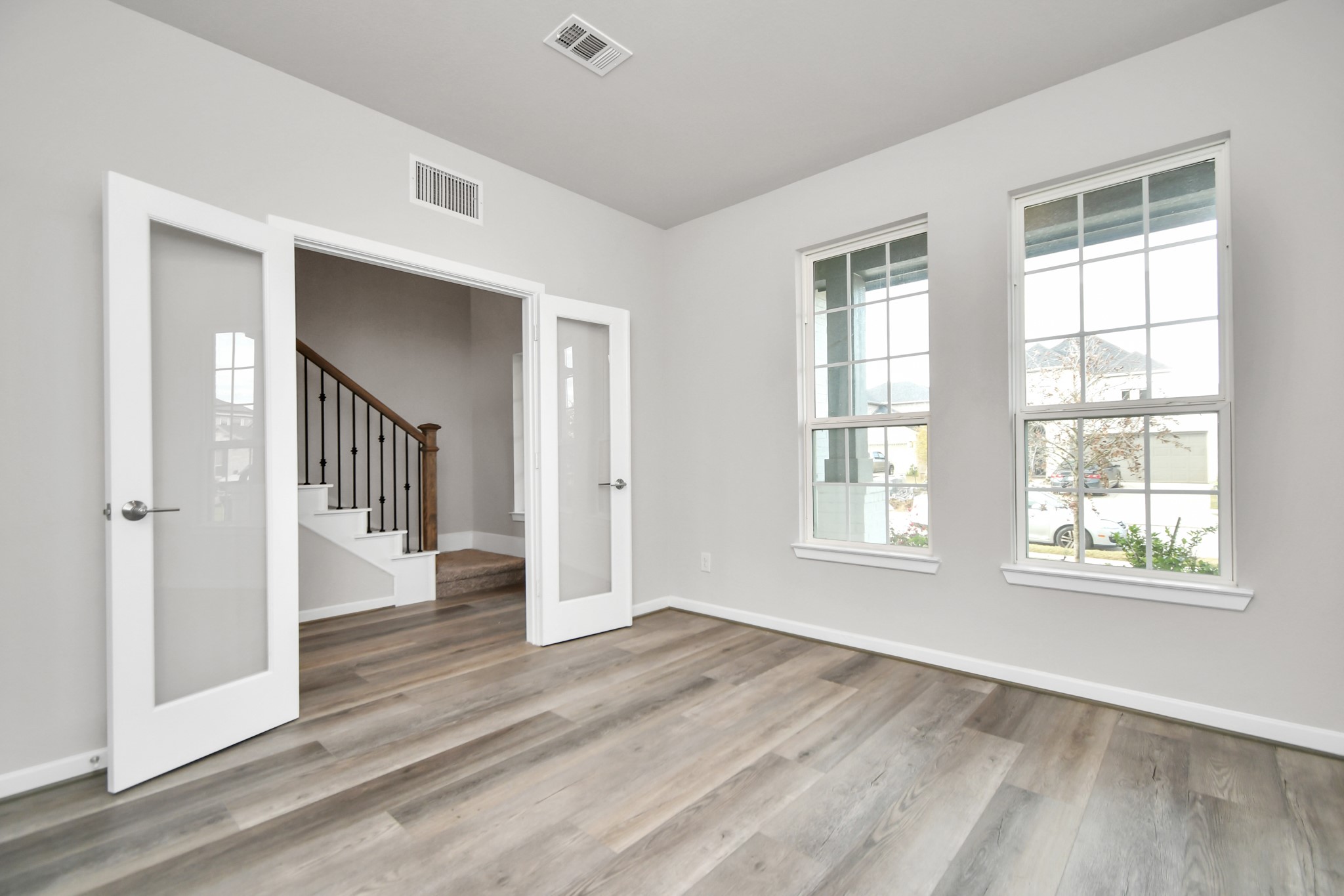 1218 Raburn Run Lane Tomball, TX 77375 - Photo 4 of 37 an empty room with wooden floor cabinet and windows