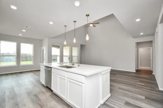 a kitchen with a sink stove and wooden floor