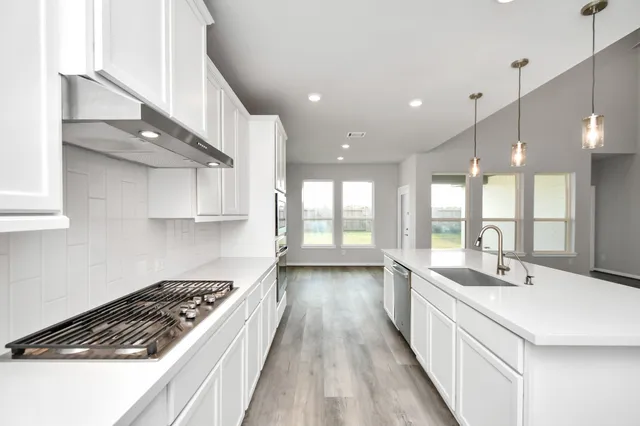 a kitchen with stainless steel appliances a sink stove and cabinets