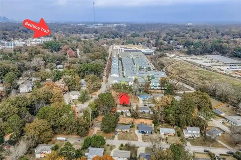 an aerial view of residential houses with outdoor space and trees