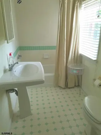 a bathroom with a sink a toilet and a mirror